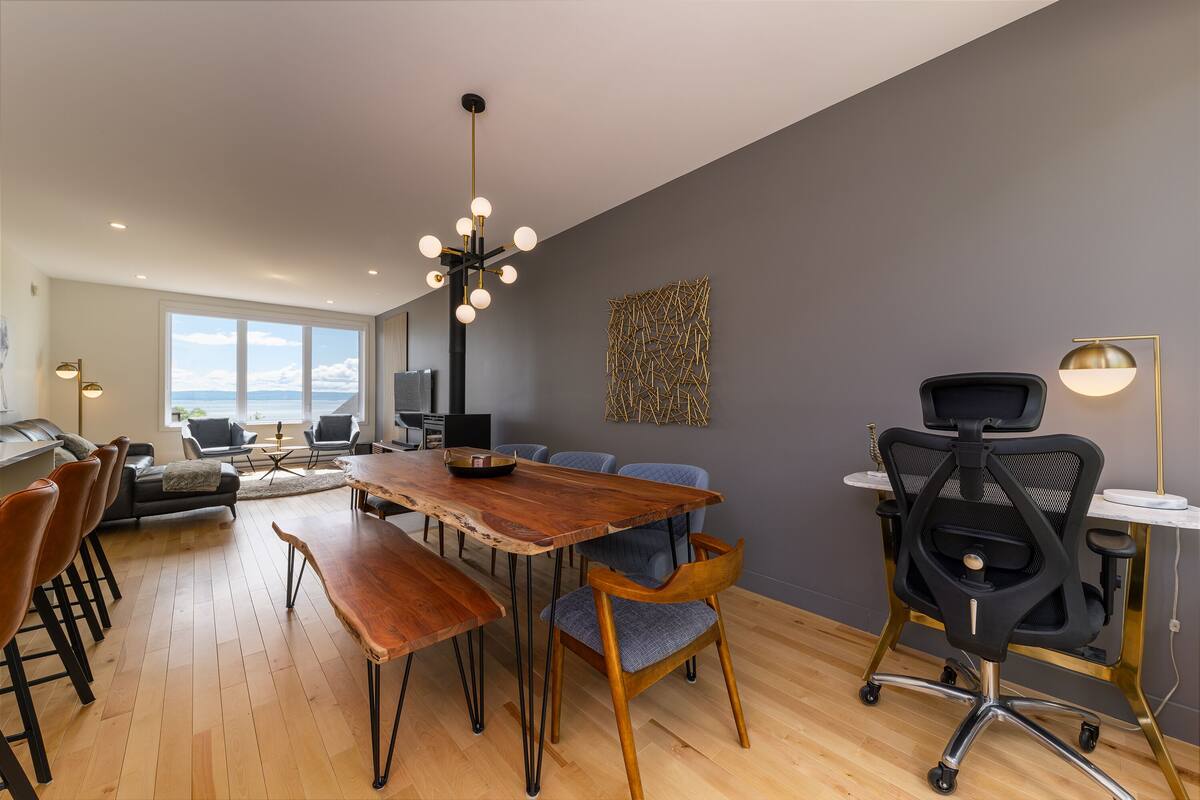 Un espace de salle à manger moderne avec une table en bois, des chaises et un lustre.