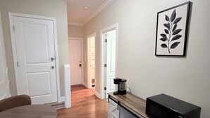 A modern kitchen with a microwave, a coffee maker, and a dining table with chairs. - Comfortable private suite in Buford North Atlanta (Buford)