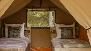 A tent with two wooden beds, each with pillows and a window. - The Turner Unit 1 - Glamping Retro (Erwin)