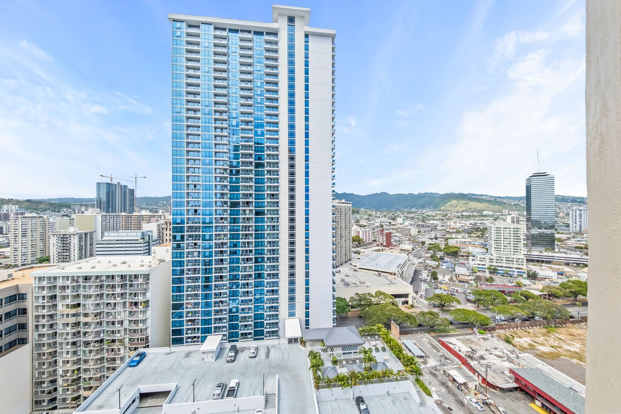 A high-rise building with a modern design, featuring a prominent blue facade and multiple floors.