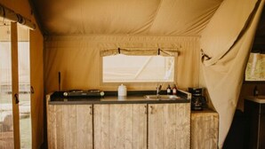 Eine kleine Küche mit Holzausstattung, einem Fenster und einer Kaffeemaschine.