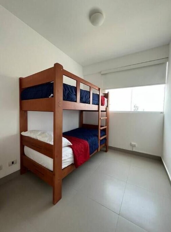 A bunk bed room with a window and a ceiling light.