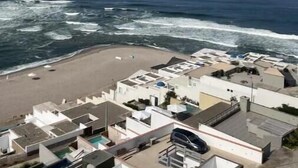 A coastal hotel with a beach view, multiple buildings, and a parking area. - Terrace with Jacuzzi, Duplex, Ocean View, Grill (Punta Hermosa)