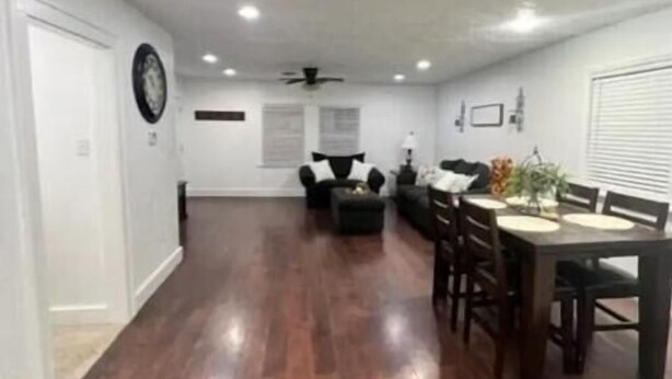 A spacious living room with hardwood flooring, a dining area with a table and chairs, and a ceiling fan. - Sunset Melody - pet friendly  (Amarillo)