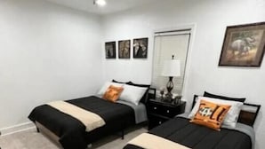 A bedroom with two beds, a ceiling fan, a nightstand, and a framed picture on the wall. - Sunset Melody - pet friendly  (Amarillo)