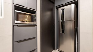 A modern kitchen with a built-in microwave and a stainless steel refrigerator. - 5 Minutes From Leblon Beach Ap302 (Rio de Janeiro)