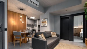 A modern living room with a grey sofa, wooden dining table, and pendant lights. - 5 Minutes From Leblon Beach Ap302 (Rio de Janeiro)