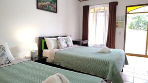 A hotel room with two beds, a nightstand, a lamp, a painting on the wall, and a window with curtains. - Hotel SantaFe Monteverde  (Monteverde)