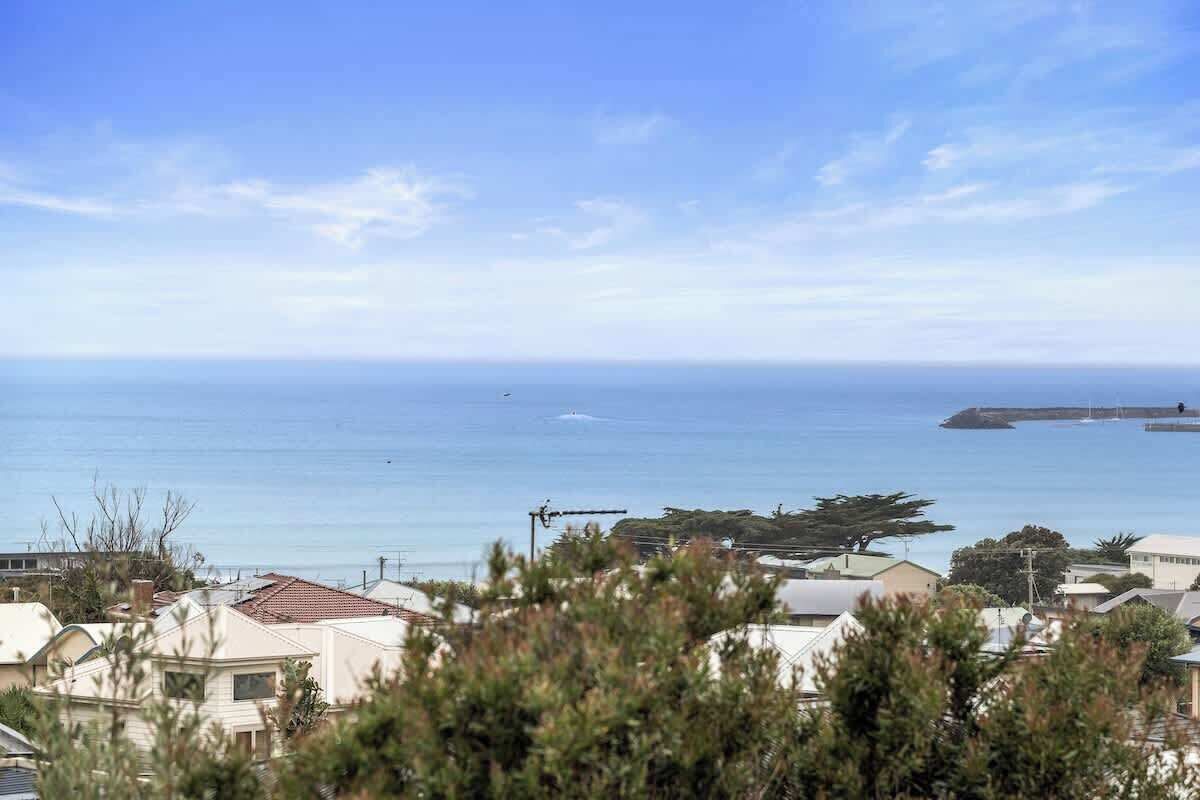 Ein Küstenwohngebiet mit Häusern, blauem Himmel und dem Meer.