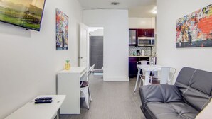 A compact living space with a kitchenette, a dining area, and a seating area.