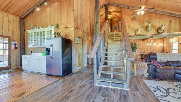Un interior espacioso de madera con cocina, comedor y una escalera.