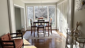 A spacious room with a dining area, a sofa, and a decorative vase.