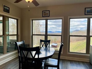 Enjoy meals in this cozy dining area with a round table and four chairs, offering a view of the surrounding mountains.