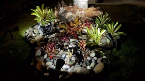 A garden with a stone sculpture, various plants, and a pathway. - Serenity get away @Oceanpointe 2BR 2BTHRM solar wifi (Lucea)