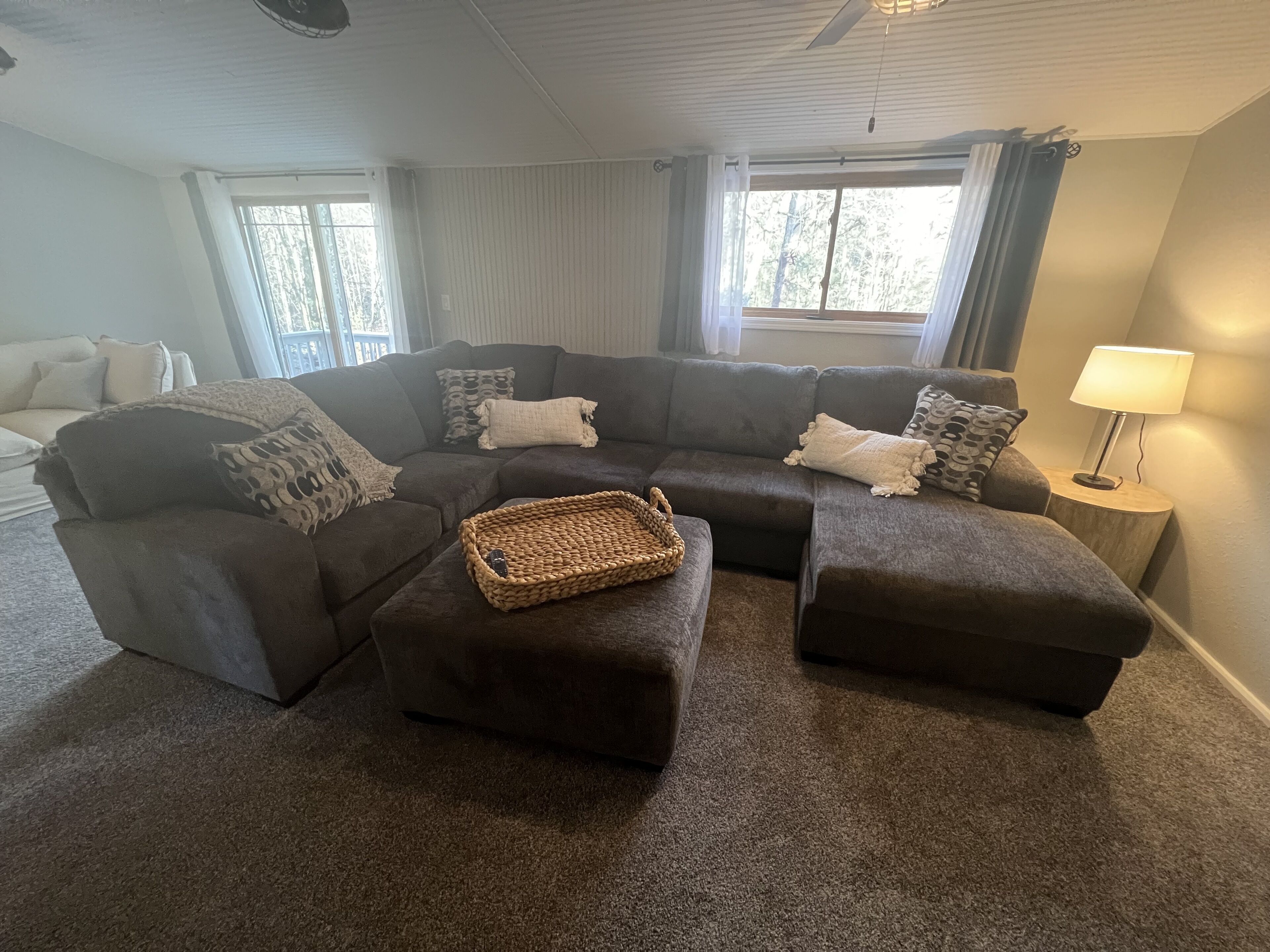 A living room with a sectional sofa, a coffee table, and a lamp.