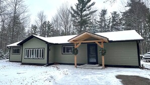 A single-story house with a gabled roof, a front porch, and a front door. - Newly Remodeled Family-Friendly Home in Woodruff Close to Everything (Woodruff)