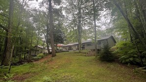 A forested area with a house and a deck. - Newly Remodeled Family-Friendly Home in Woodruff Close to Everything (Woodruff)