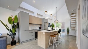 A modern kitchen with a central island, bar stools, and pendant lighting. - Beautifull Penthouse 2 bedrooms/2 bathrooms condo with private terrasse. (Montréal)
