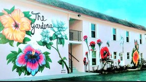 A building with a mural of flowers and the text "The Gardenia."