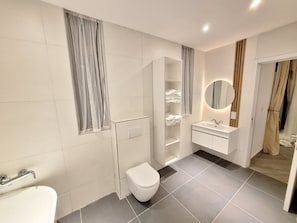 Une salle de bain moderne équipée de toilettes, d’un lavabo et d’une baignoire.