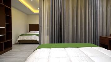 Quarto moderno com uma cama grande, uma cama menor, um guarda-roupa e uma escrivaninha.