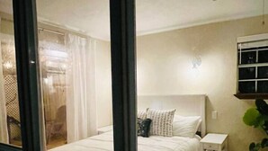 A bedroom with a bed, bedside table, and a ceiling fan. - `Dunes` Gulf-View Historic Beachside Cottage 1/1 (Indian Rocks Beach)