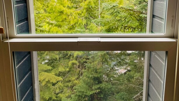 A window with a view of a forest and mountains. - Spacious Town Home, Sleeps 8, Walk to Gondola! (Whistler)