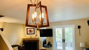 A living room with a fireplace, a television, and a dining area. - Spacious Town Home, Sleeps 8, Walk to Gondola! (Whistler)
