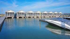 Een jachthaven met verschillende woonboten die in kalm water liggen aangemeerd.