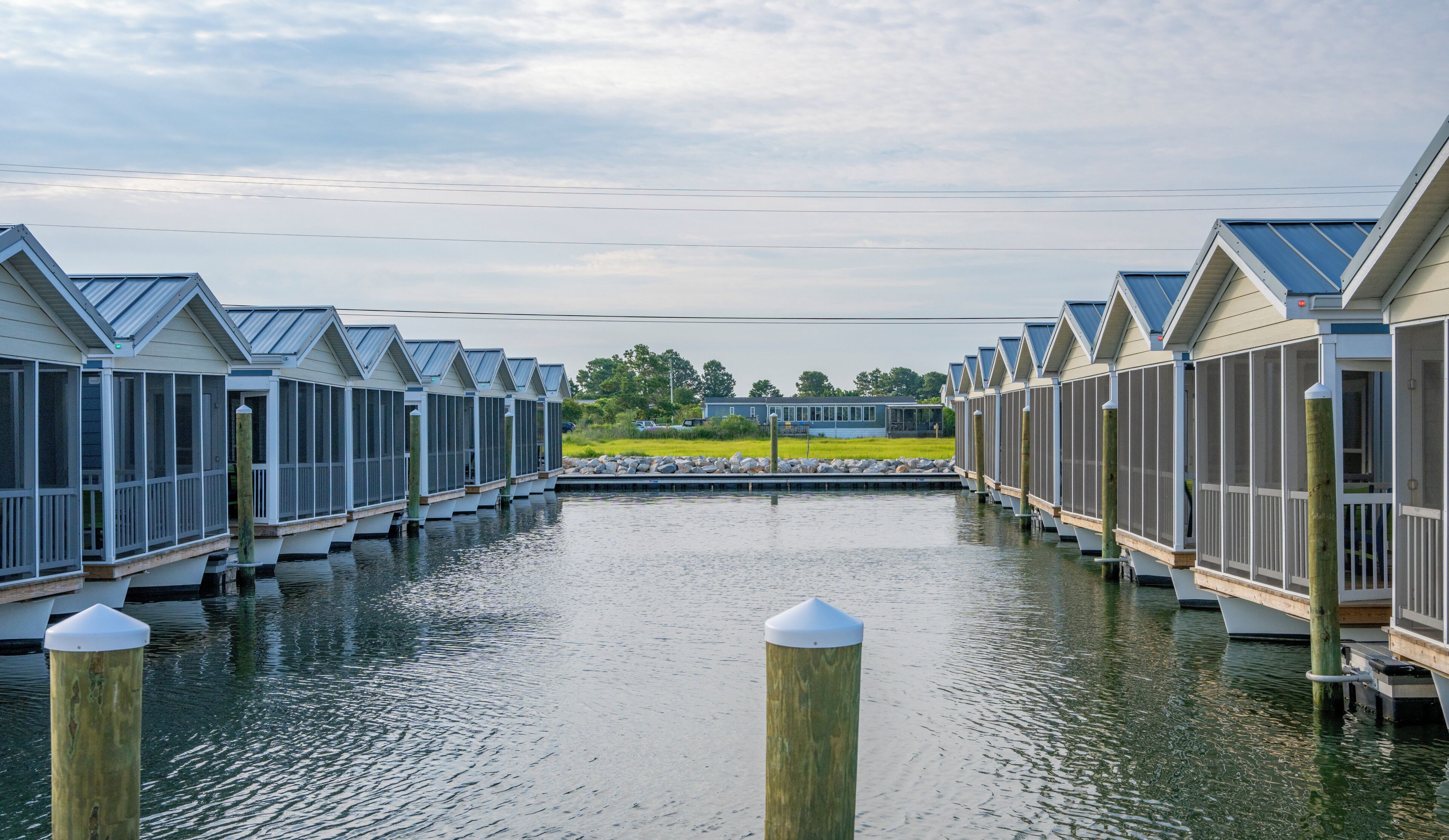 A row of waterfront cottages with a dock in the middle.