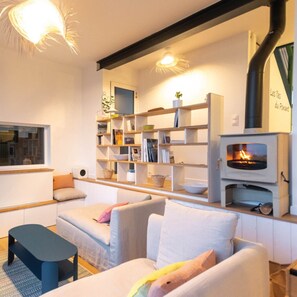 Una sala de estar acogedora con chimenea, estanterías empotradas y un rincón de asientos confortable.
