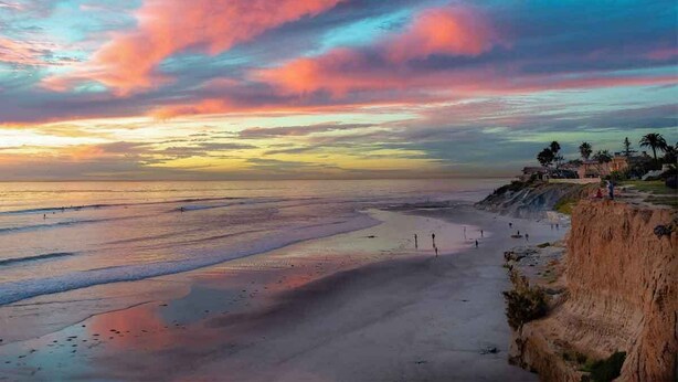 A beach with a sunset, clear sky, and a cliff with buildings. - Clean Private Bedroom,Bathroom. Private entrance. Lovely Gated Neighborhood.     (Vista)