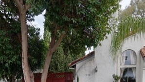 A residential property with a landscaped garden, a white stucco exterior, and a red gate. - Clean Private Bedroom,Bathroom. Private entrance. Lovely Gated Neighborhood.     (Vista)