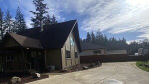 A residential property with a large driveway, a covered porch, and a garage.