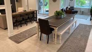 Una cocina moderna con comedor, un ventanal grande y una sala de estar con sofá y mesa de centro.