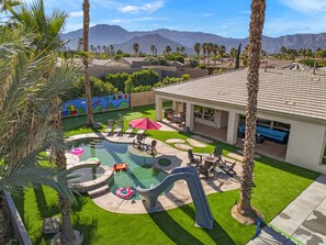 A backyard with a pool, lounge chairs, and a patio area. - Super Mario Hideout Desert Dream (Indio)