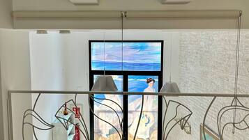 A modern interior with a large window, a metal railing, and a view of the outdoors.