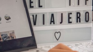 A laptop on a table with a sign in the background that reads "EL TIP VIAJERO" and a heart symbol. - El Tip Viajero, Apartaments and Coworking  Lima Perú (San Martín de Porres)
