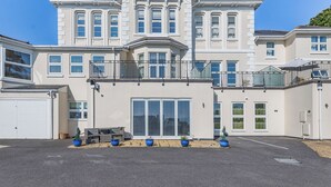 A large, multi-story building with a symmetrical facade, large windows, and a central entrance. - 2 bedroom accommodation in Torquay (Torquay)
