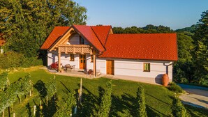 Ein Haus mit rotem Dach, einer Veranda und einem Garten.