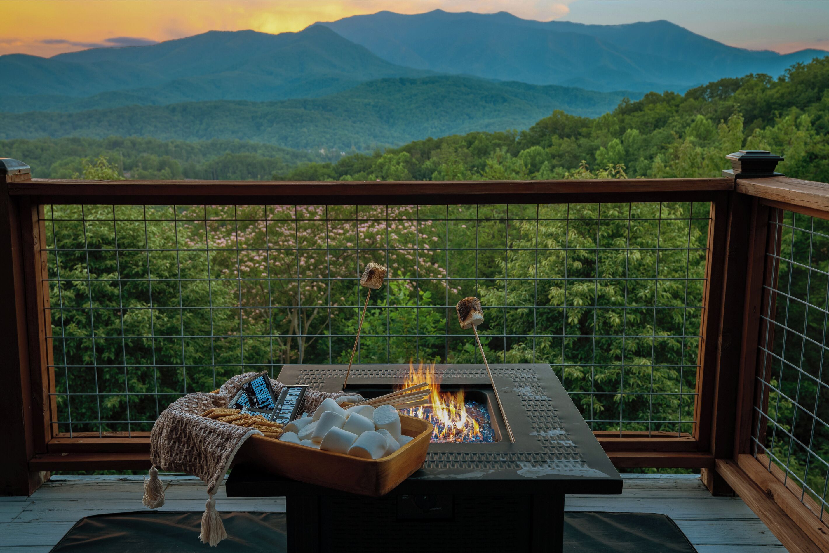 A balcony with a fire pit, marshmallows, and a laptop.