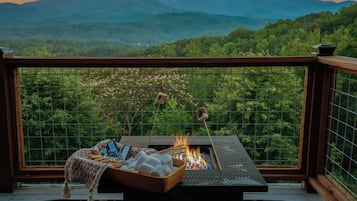A balcony with a fire pit, marshmallows, and a laptop.