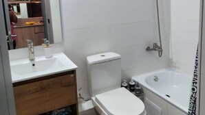 A modern bathroom with a toilet, sink, and bathtub. - Acogedor Loft Centro De Santiago (Santiago)