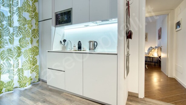 A modern kitchen with white cabinets, a built-in microwave, and a coffee maker. - GuestHost - Near the MIND neighborhood, the Milano Laghi highway, and in front of the Milano Certosa station near Rho Fiera, there's the two-room apartment with garage and garden at Casa Certosa&Mind, a new and welcoming space for three guests. Bright, w (Milan)