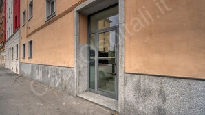 A building with a glass door entrance, a visible number '6' on the wall, and a narrow sidewalk. - GuestHost - Near the MIND neighborhood, the Milano Laghi highway, and in front of the Milano Certosa station near Rho Fiera, there's the two-room apartment with garage and garden at Casa Certosa&Mind, a new and welcoming space for three guests. Bright, w (Milan)