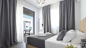 Une chambre d’hôtel moderne avec un grand lit, des rideaux gris, une table de chevet agrémentée d’une plante, et une vue sur la ville par la fenêtre.