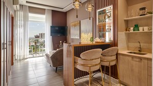 Een moderne keuken met een bar, een eethoek met een bank en een televisie.