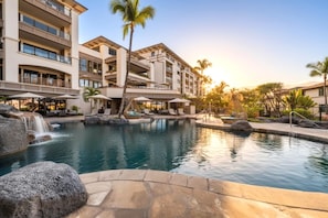 A hotel with a pool, palm trees, and a waterfall. - Wailea Beach Villas Resort by KBM (Kihei)