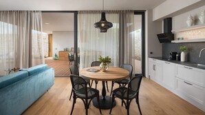 A modern kitchen with white cabinets, a black countertop, and a hanging light fixture. - Beautiful home in Vodnjan with sauna (Vodnjan)