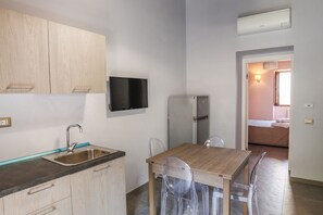 A modern kitchen with a wooden countertop, stainless steel sink, and a built-in refrigerator.